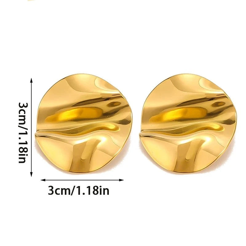AURUM Golden Mirror 18K
Imagem de brinco circular dourado com superfície espelhada e ondulações suaves, sobre fundo claro.