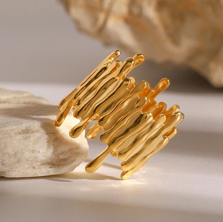 AURUM Liquid Gold 18K
Imagem de anel banhado a ouro 18K com superfície escultural e textura líquida, fotografado sobre fundo neutro.