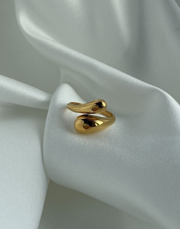 Anel Gota 18K em aço cirúrgico banhado a ouro, com design fluido em forma de gota e acabamento polido brilhante, sobre fundo branco minimalista.