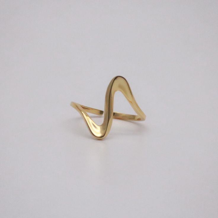 Anel Ripple 18K de aço cirúrgico banhado a ouro com design fino, ondulado e polido, formando curvas suaves e elegantes.