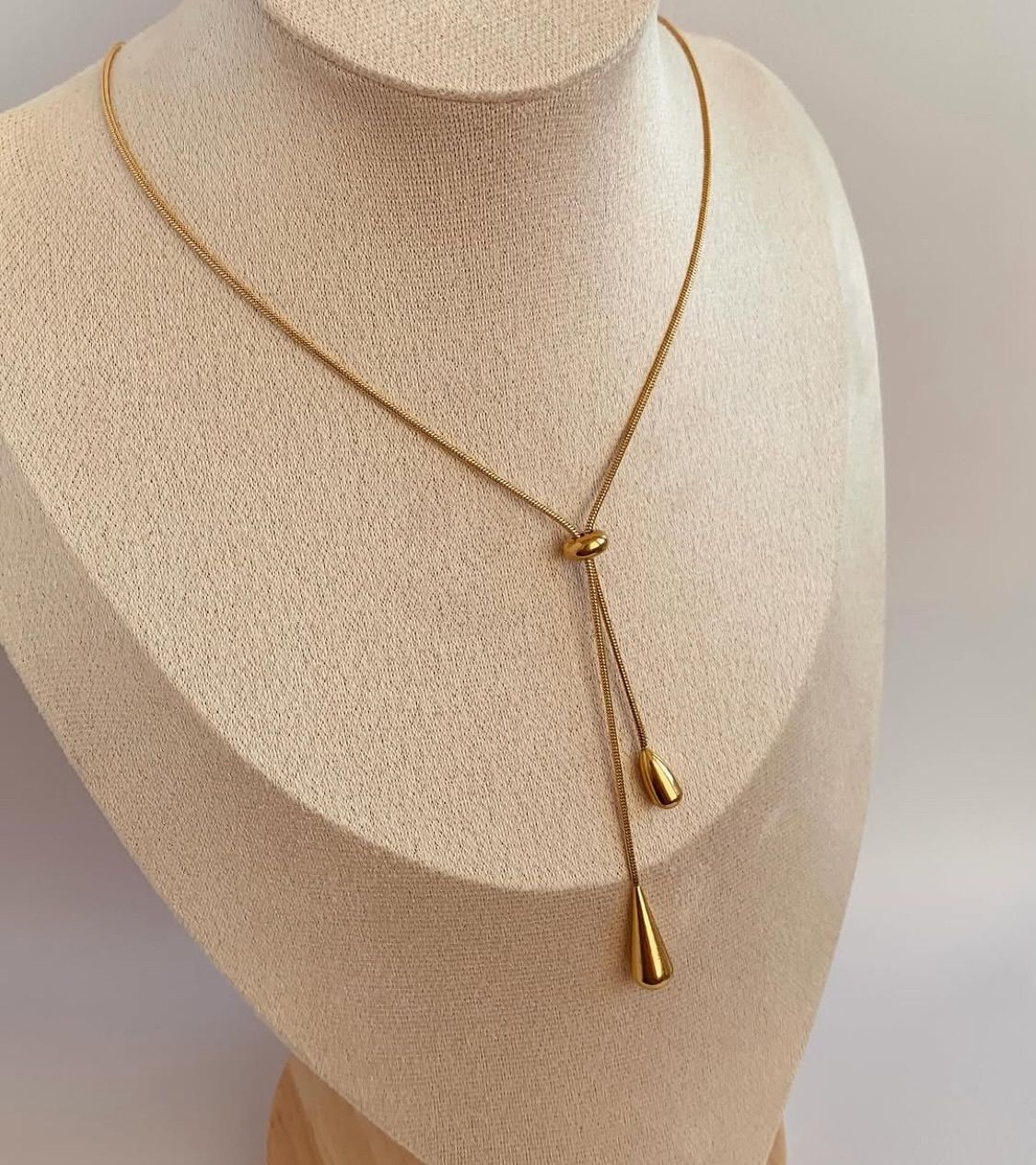 Colar de ouro estilo minimalista com pingentes em forma de gota sobre o colo de uma modelo — Colar Essence 18K AURUM