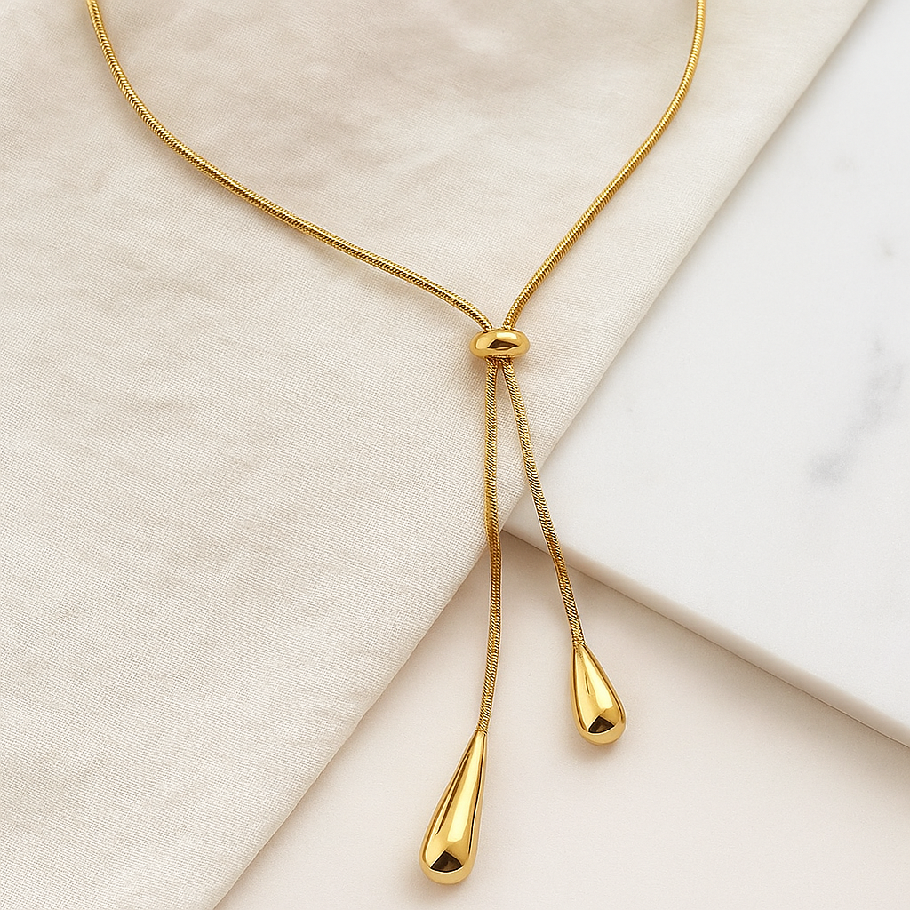 Colar de ouro estilo minimalista com pingentes em forma de gota sobre o colo de uma modelo — Colar Essence 18K AURUM
