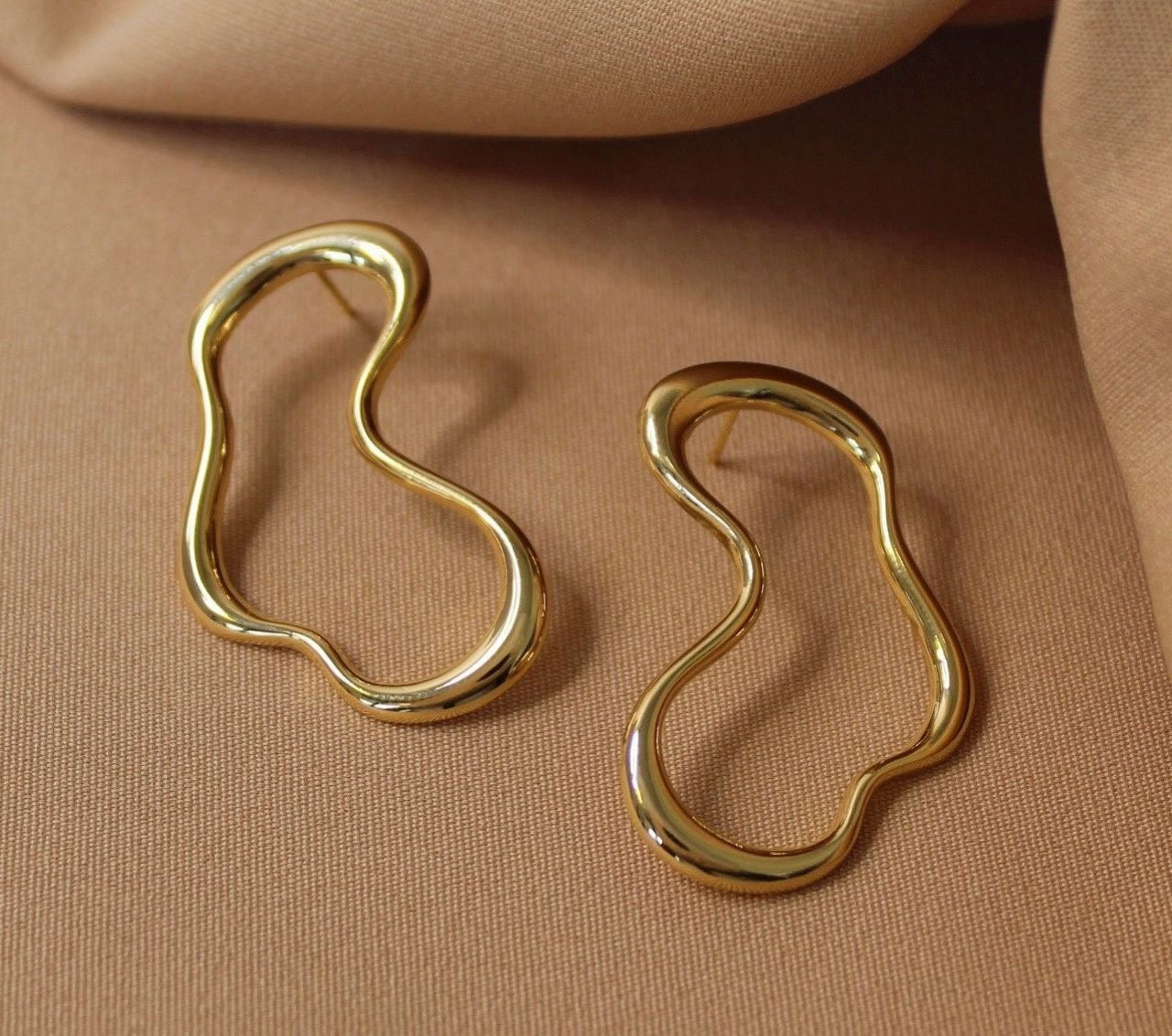 AURUM Alma 18K
Imagem de brinco com curvas orgânicas e estrutura assimétrica, acabamento polido, fundo limpo.