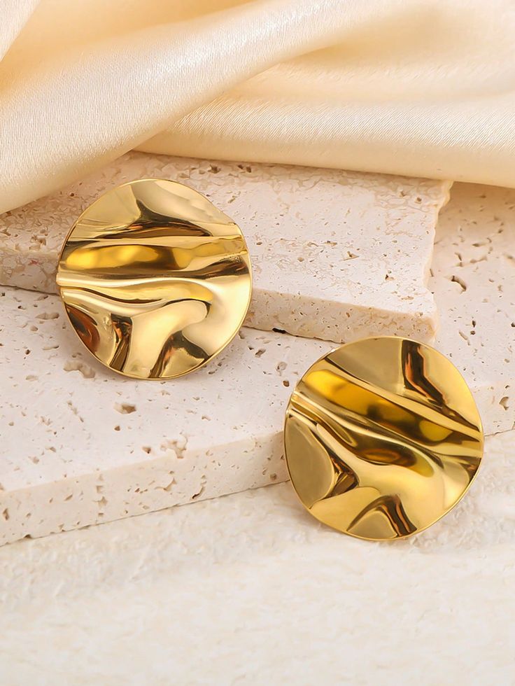 AURUM Golden Mirror 18K
Imagem de brinco circular dourado com superfície espelhada e ondulações suaves, sobre fundo claro.