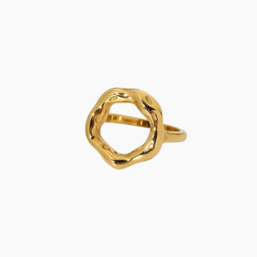 Anel dourado com design escultural e aberto, formado por um aro grosso e irregular em formato circular orgânico, com acabamento polido e levemente ondulado, evocando a imagem de um eclipse. A peça tem superfície espelhada e textura fluida, destacando-se em fundo claro minimalista.

