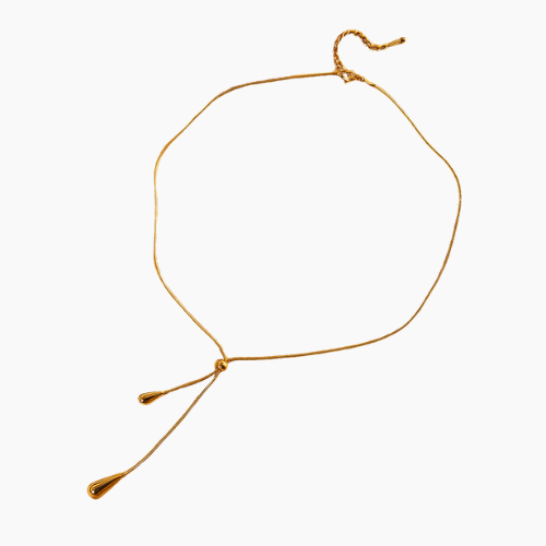 Colar de ouro estilo minimalista com pingentes em forma de gota sobre o colo de uma modelo — Colar Essence 18K AURUM
