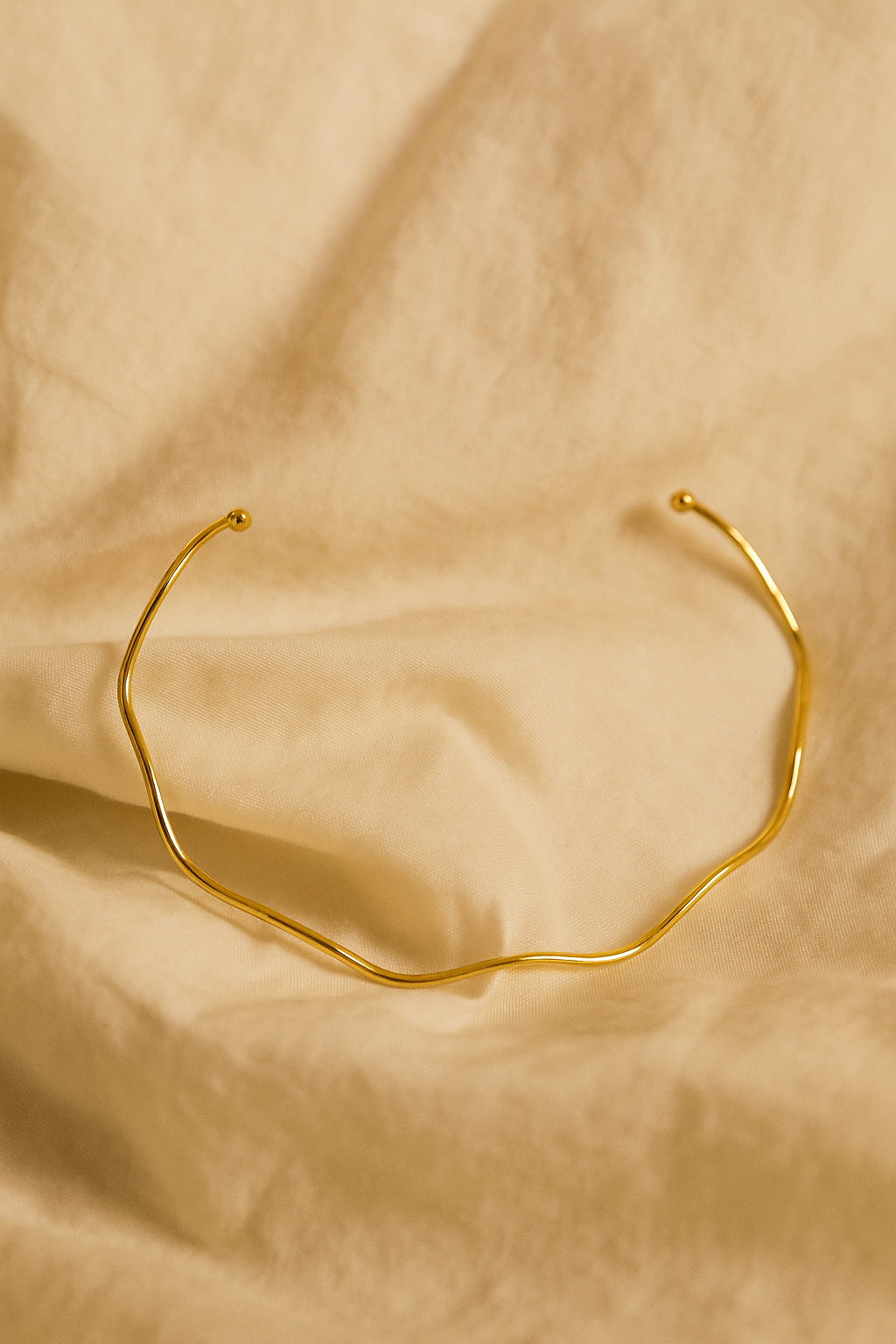 Colar AURUM Halo 18K em aço cirúrgico banhado a ouro, com formato ondulado minimalista, fotografado sobre fundo branco.