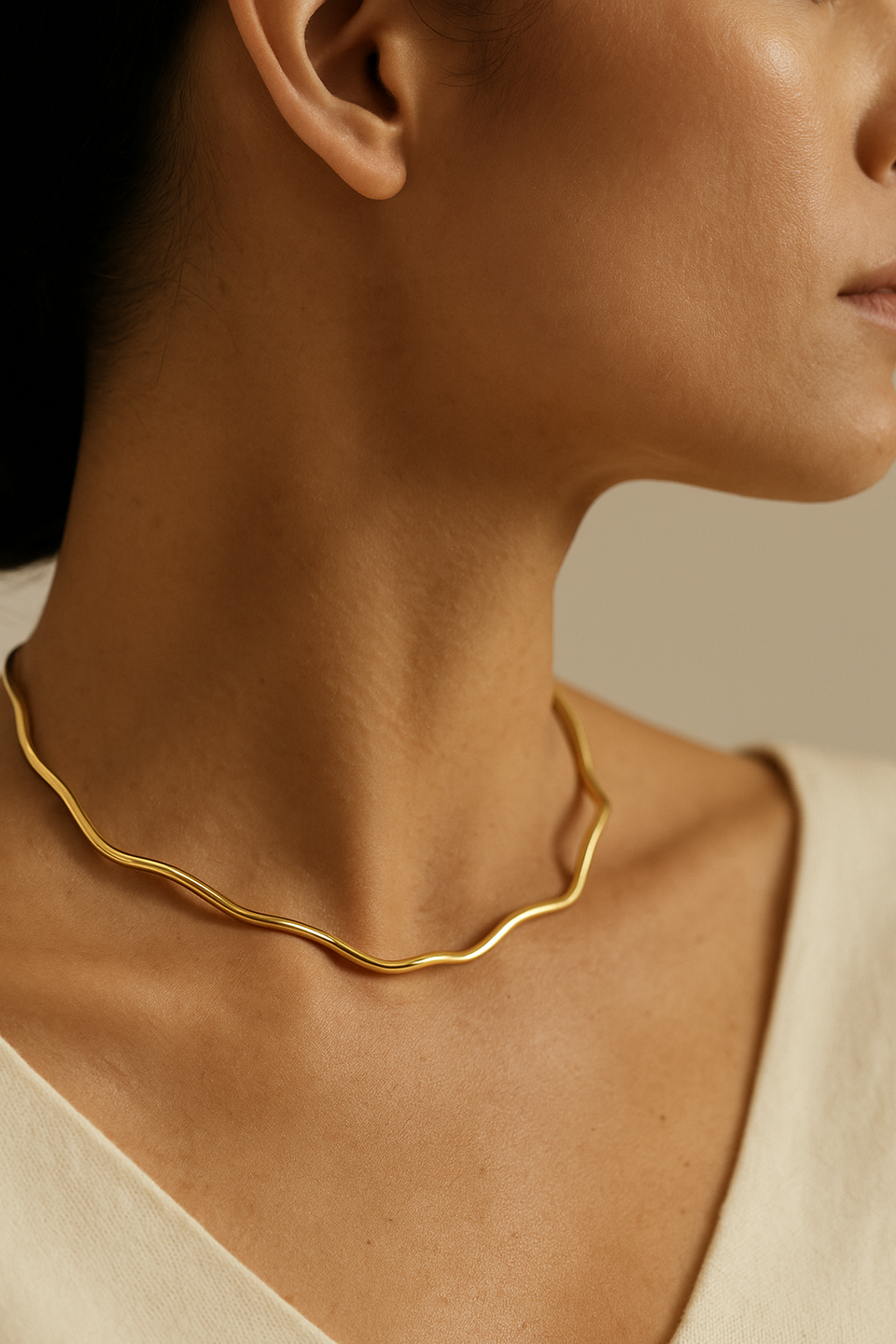 Colar AURUM Halo 18K em aço cirúrgico banhado a ouro, com formato ondulado minimalista, fotografado sobre fundo branco.