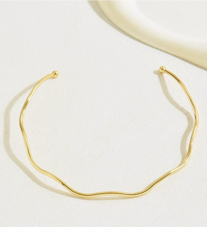Colar AURUM Halo 18K em aço cirúrgico banhado a ouro, com formato ondulado minimalista, fotografado sobre fundo branco.