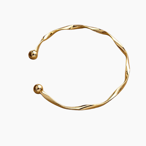 Pulseira rígida banhada a ouro com design torcido e extremidades arredondadas em formato de esferas, apoiada sobre uma caixa de textura sofisticada em tom marrom claro.